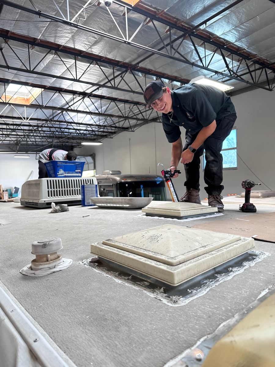 Technician installing a new RV roof vent cover