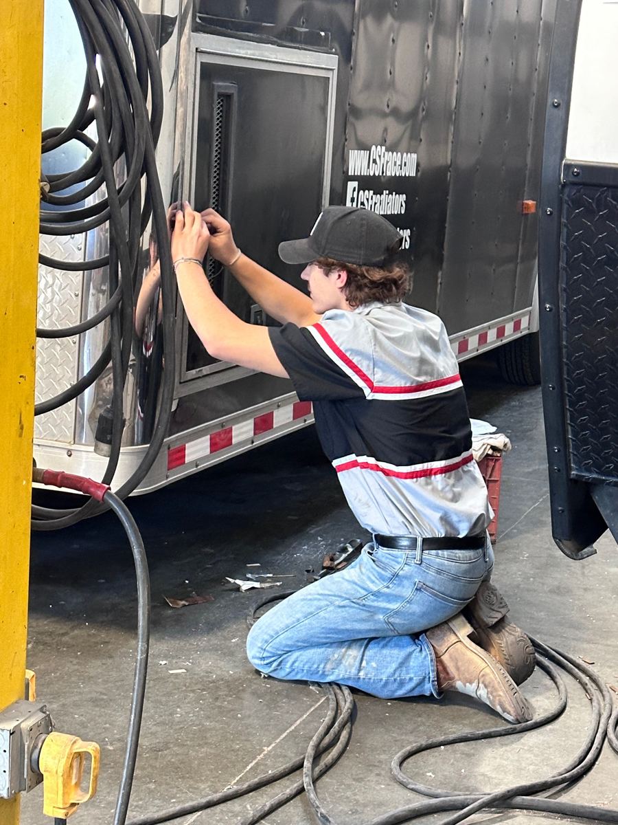 Technician servicing a trailer side vent and generator compartment